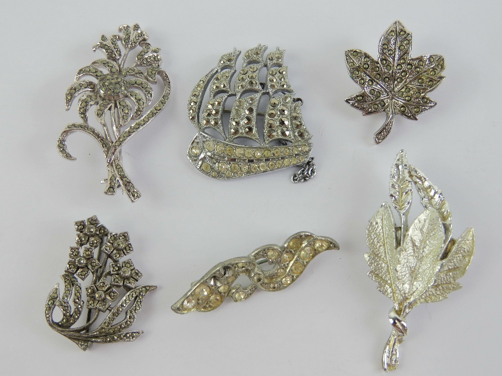 A quantity of costume jewellery brooches including a ship and marcasite floral spray.