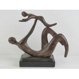 A bronzed brass sculpture of child and parent playing, 32cm wide.