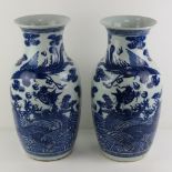 A pair of oversize blue and white Chinese shoulder vases having mythical beast design upon,