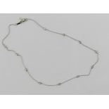 A 14ct white gold necklace having eleven round cut diamonds upon, stamped 585, adjustable length,