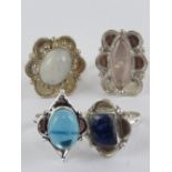 Four hardstone rings each stamped 925, size S-T, including moonstone and lapis lazuli.