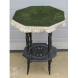 An ebonised octagonal table raised over four turned legs.