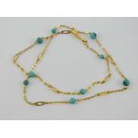 A 9ct gold necklace having chain sections with alternating faux turquoise and oval panels,