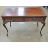 An Edwardian mahogany twin drawer freize table raised over shaped slender cabriole legs terminating
