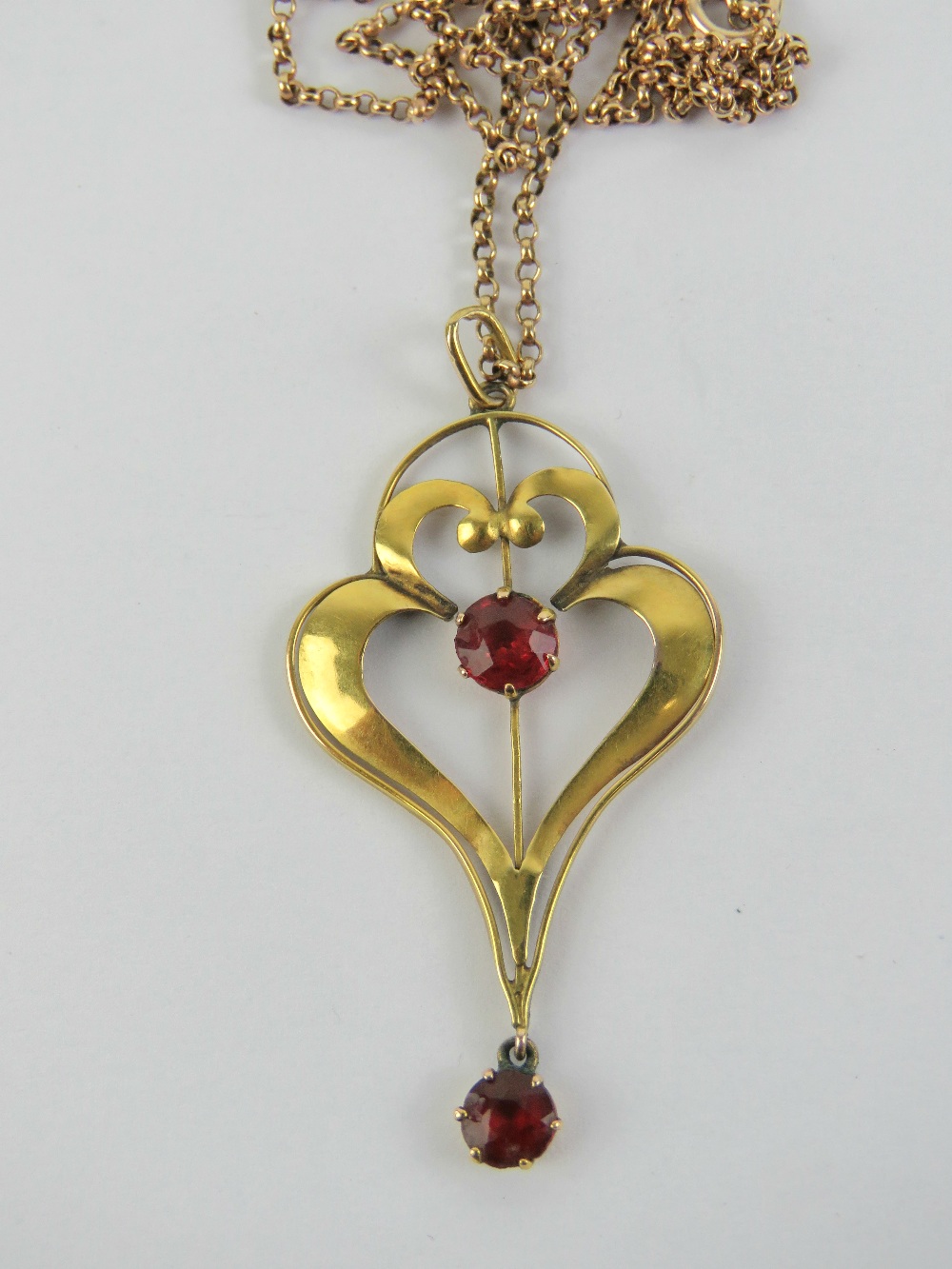 A delightful 9ct gold Edwardian heart shaped red stone pendant, stamped 9ct,