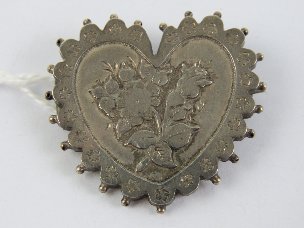 A late Victorian silver heart shaped mourning brooch having applied floral decoration,