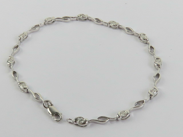 A 9ct white gold and diamond bracelet, each of the eleven diamond in rubover setting,