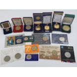 Four boxed mint collectors coins together with ten collectors coins in protective pod/packages.