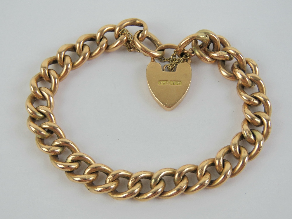 A 15ct gold charm bracelet with heart padlock clasp, stamped 15ct throughout,