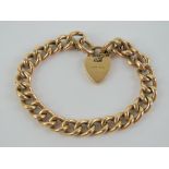 A 15ct gold charm bracelet with heart padlock clasp, stamped 15ct throughout,