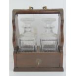 A tantalus having pair of decanters with original stoppers and complete with key,