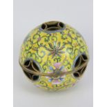 A Chinese Canton enamel on brass hand warmer, having yellow ground with floral decoration upon,