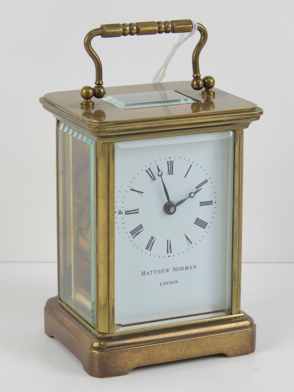 A Matthew Norman five glass brass carriage clock having swing handle over, with key.