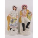 A pair of 19th century Staffordshire flatback figurines being man and woman each holding a woven