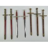 Five miniature decorative swords with scabbards,