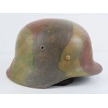 A WWII German M42 camouflage helmet with liner and chin strap, marked within 2407 ET-66.