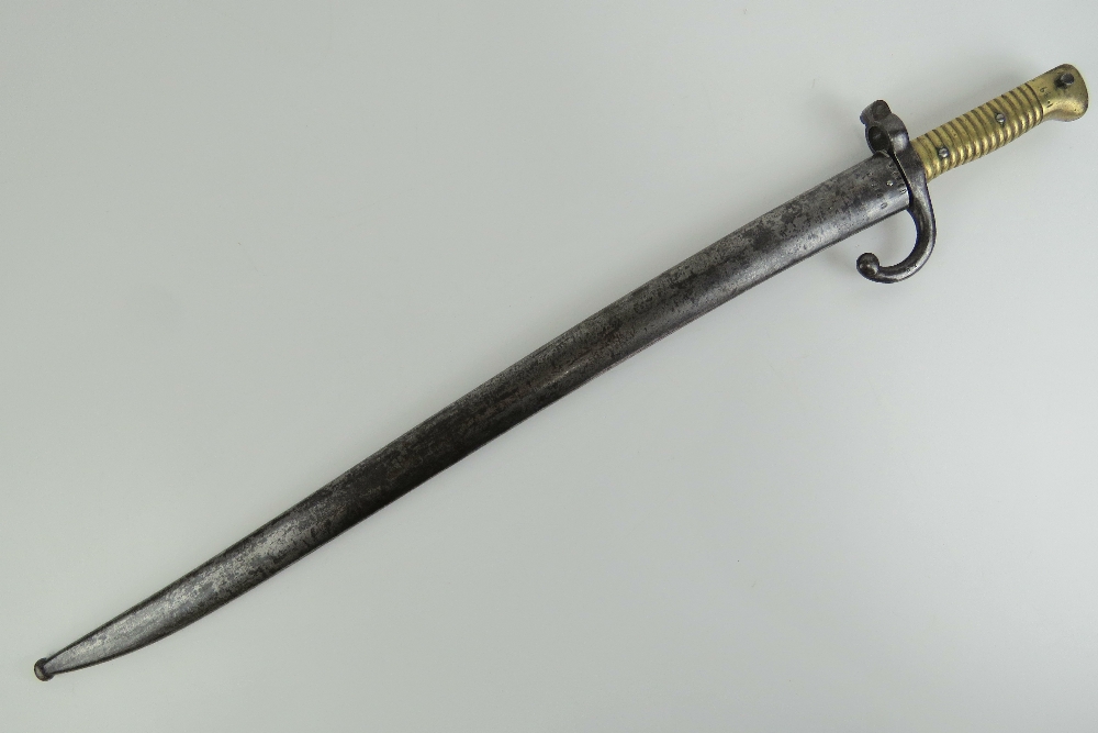 A Remington rolling block bayonet with brass grip, 57cm blade, with quillian, with scabbard.
