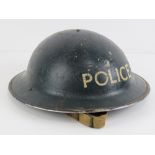 A WWII British Police helmet having liner and chin strap.