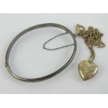 A silver heart shaped pendant on fine white metal chain,