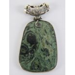 A large green hardstone pendant having hinged white metal pierced bale over, 6cm in length.