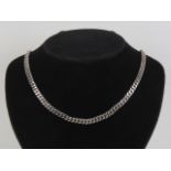 A heavy silver flattened curb link chain necklace complete with safety chain,