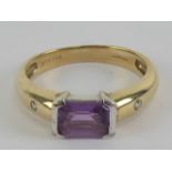 A 9ct gold Amethyst and diamond ring, the central emerald cut amethyst approx 0.