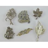 A quantity of costume jewellery brooches including a ship and marcasite floral spray.