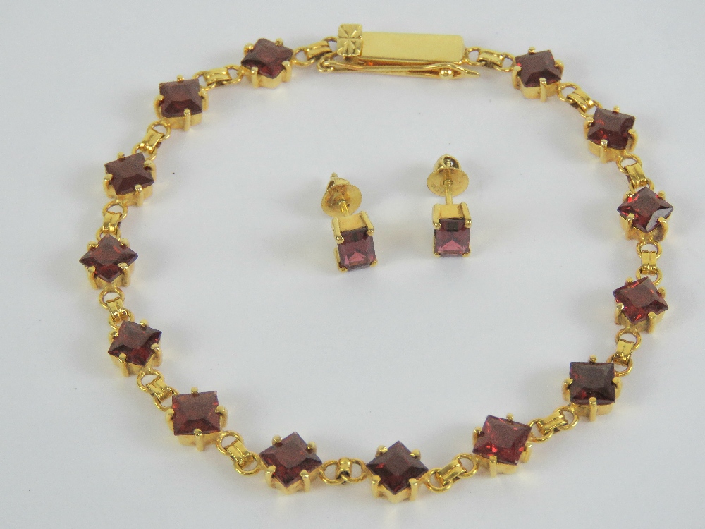 A 14ct gold and garnet bracelet, the 14 square cut garnets each approx 0.