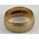 A 9ct gold ring having engraved border pattern, hallmarked 375, size N, 3.9g.
