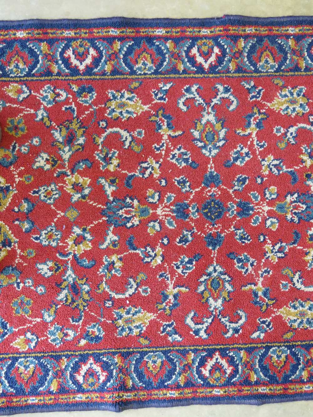 A woollen and silk rug in reds and blues having floral decoration upon 135 x 65cm. - Image 2 of 2