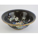 A Chinese Canton enamel bowl having black ground with blue border and base,