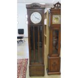 A c1930s stained oak long case hall clock circular 24cm dial with Arabic numerals upon all before