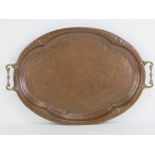 A hand planished copper tray with brass end handles measuring 56cm wide.