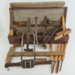 A vintage wooden tool box with leather handle containing a quantity of assorted vintage tools.