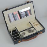 A blue leatherette jewellery box in the form of a suitcase,