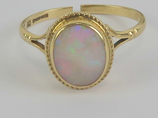 A 9ct gold opal ring having green/red fire, opal measuring 9 x 6.