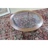 A mid 20th century G-Plan Astro circular coffee table having glass insert over quatroform base,