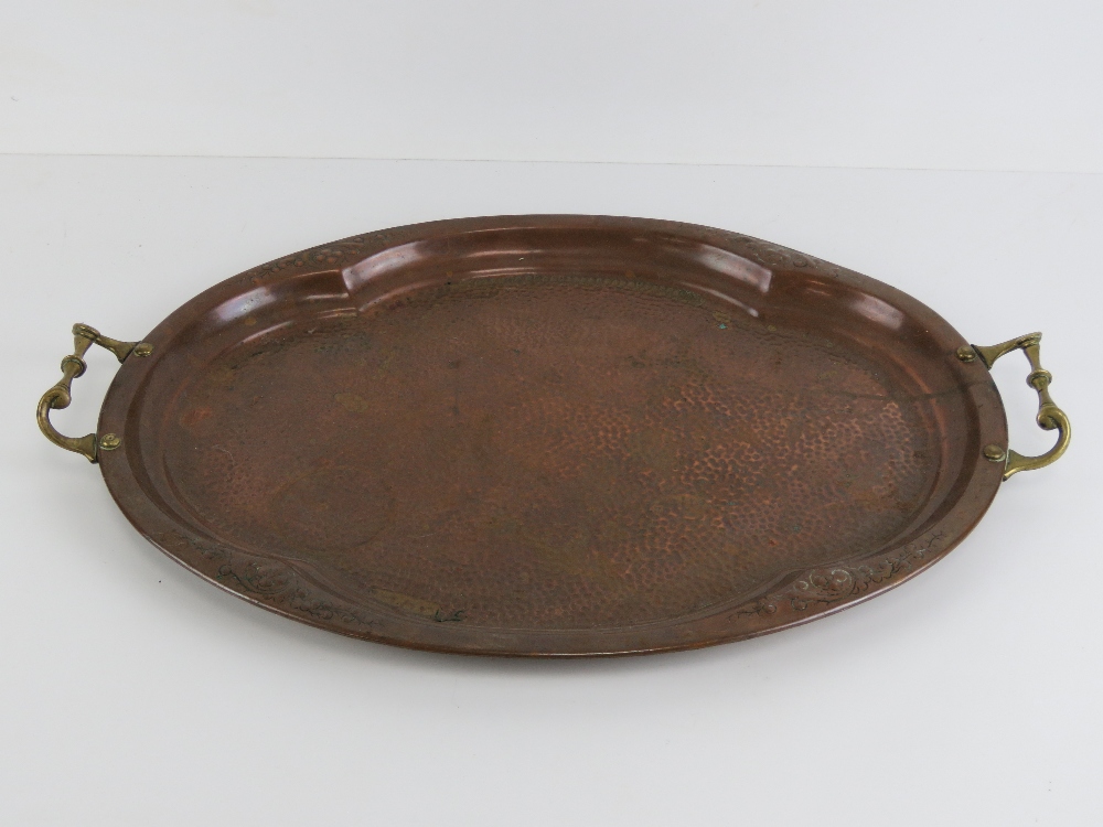 A hand planished copper tray with brass end handles measuring 56cm wide. - Image 2 of 2