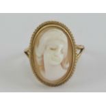 A 9ct gold ring a having oval carved shell female cameo in rope twist setting, hallmarked 375,