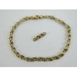 A 9ct gold bracelet having white bar on yellow oval links,