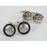 A pair of black enamelled cufflinks in the form of steering wheels,