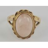 A 9ct gold rose quartz ring, the central oval cabachon measuring approx 14 x 10mm, stamped 9ct,