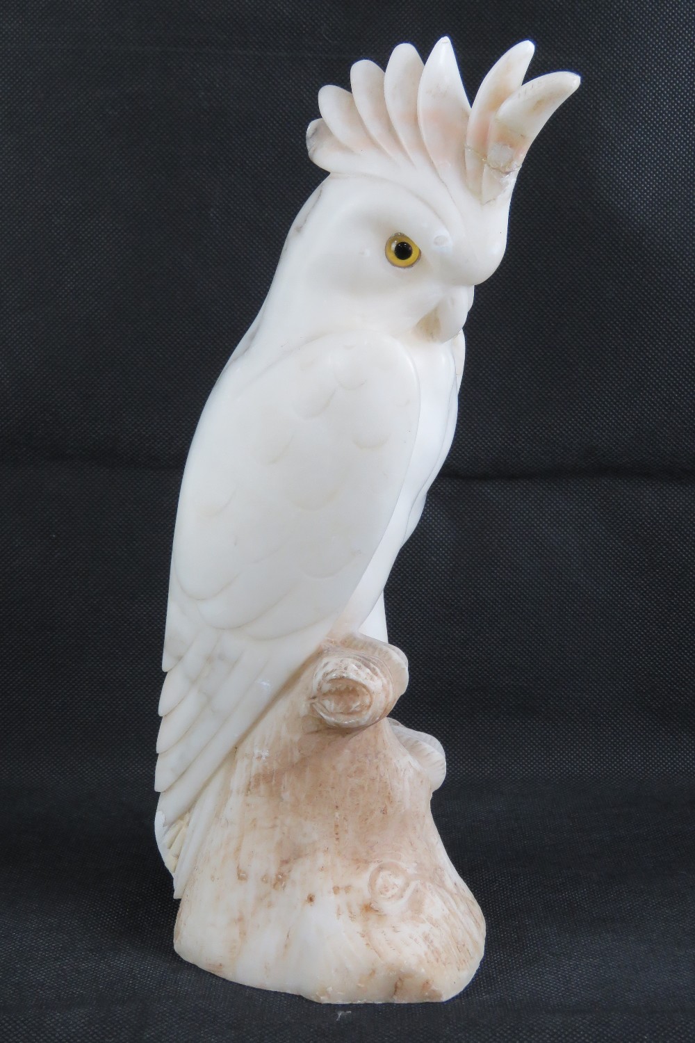 A 19th century carved alabaster cockateal a/f to crest, with glass eyes, 33cm high.
