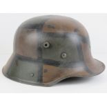 A reproduction WWI German M17 helmet in camouflage paint, with liner.