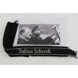 A WWII German SS Officers cuff title 'Julius Schreck' having tunic remnants attached.