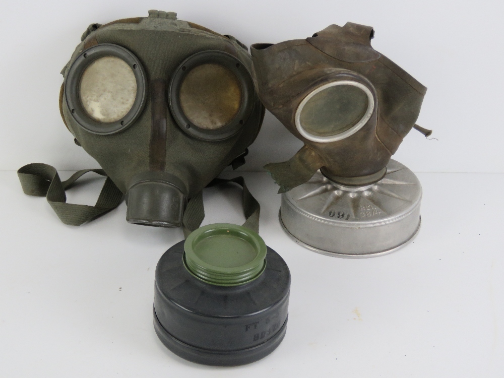 A WWII German Air Defence gas mask with filter, together with a civilian gas mask with filter.