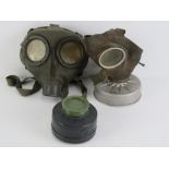 A WWII German Air Defence gas mask with filter, together with a civilian gas mask with filter.