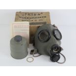 A WWII Dutch gas mask, filter in box with paperwork.