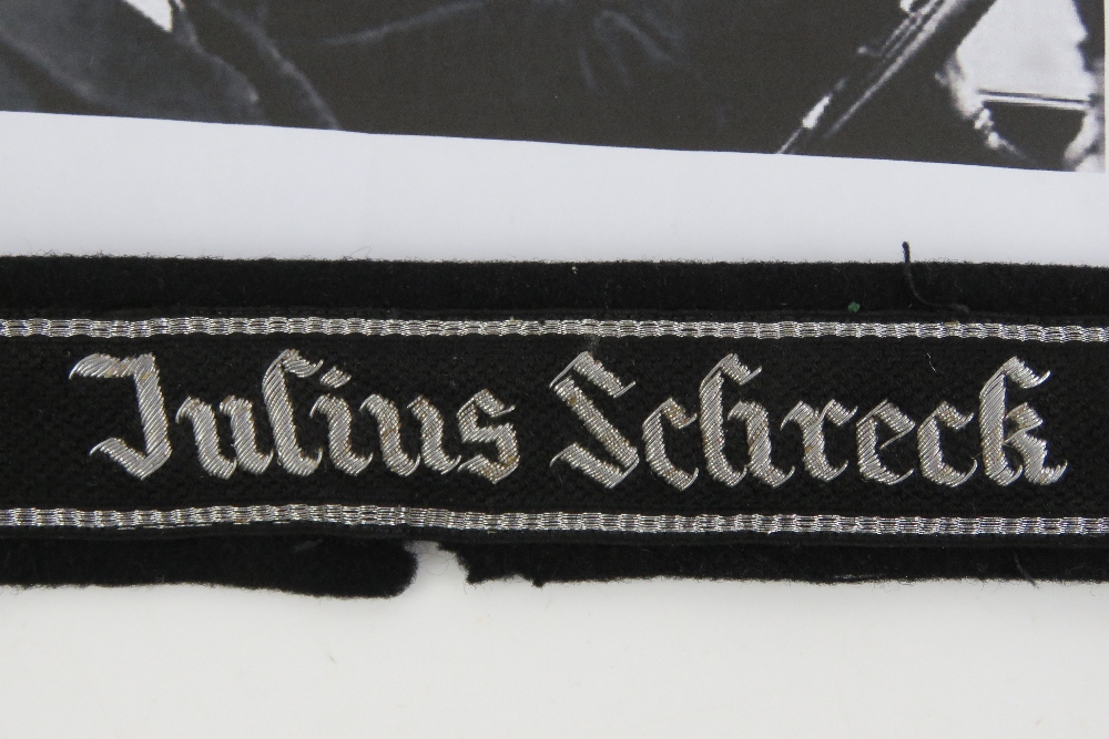 A WWII German SS Officers cuff title 'Julius Schreck' having tunic remnants attached. - Image 2 of 3