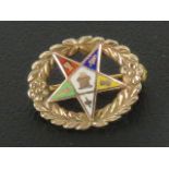 Masonic; A 10ct gold enamelled pentagram a wreath pin or brooch, stamped 10k, 15mm wide.